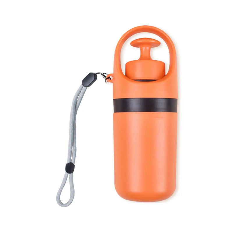 Portable dog poop scooper in orange plastic with a wrist strap and black band.