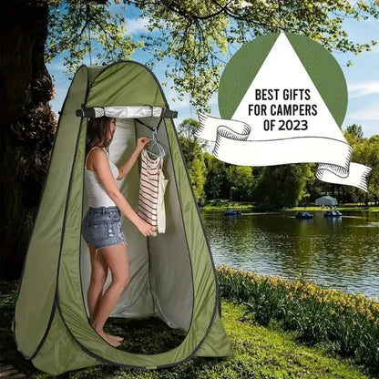 Pop-Up Privacy Tent olive-green privacy enclosure by ViralGalleria.com beside a lakeside park.
