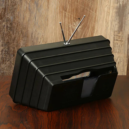 Screen magnifier for phones, black plastic ribbed stand with phone slot.
