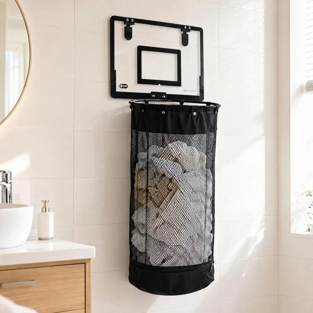 A black mesh laundry hamper with a built-in basketball hoop, shown hanging on a white tiled bathroom wall next to a sink and mirror.

Large-capacity hanging laundry basketball hamper