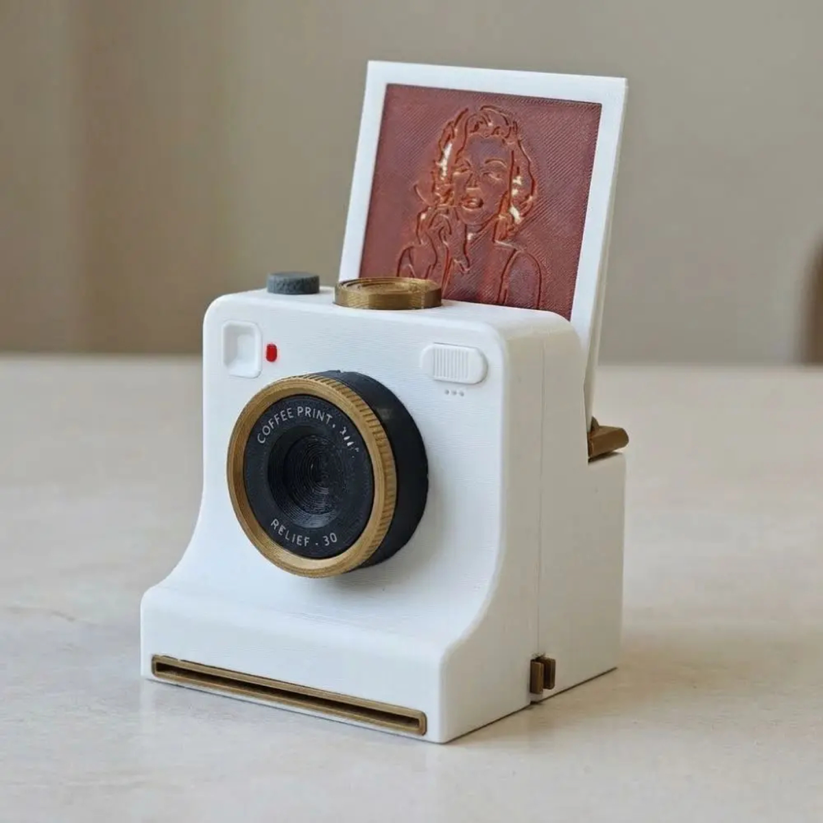 White camera-shaped latte art stencil tool with a portrait design card